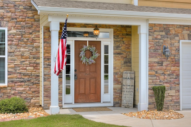 doorway to property featuring a shingled roof, brick siding, and stone siding