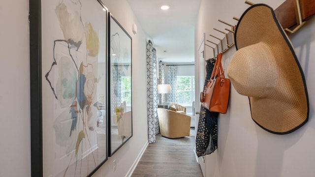 corridor featuring baseboards, wood finished floors, and recessed lighting