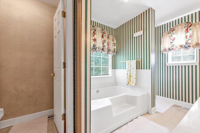 3974 Bolton St, Augusta, GA 30909 - bathroom featuring wallpapered walls, baseboards, a bath, tile patterned floors, and toilet