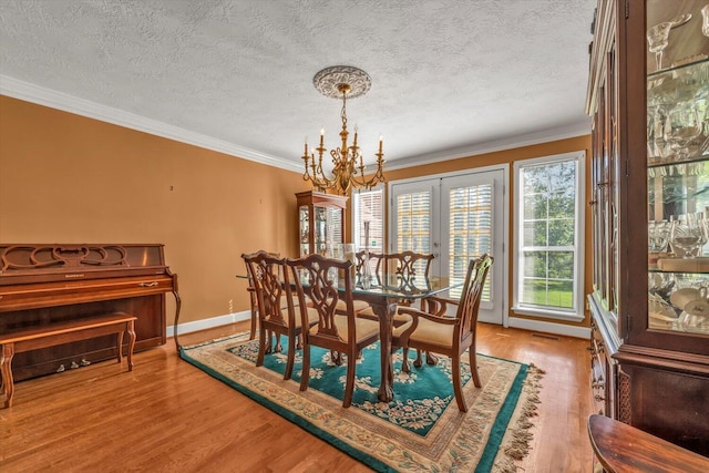 3974 Bolton St, Augusta, GA 30909 - dining area with a chandelier, wood finished floors, ornamental molding, baseboards, and a textured ceiling