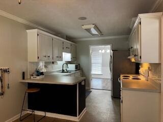 4512 Country Glen Cir, Grovetown, GA 30813 - kitchen with crown molding, white cabinets, light countertops, and a peninsula