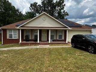 4512 Country Glen Cir, Grovetown, GA 30813 - ranch-style house featuring a porch, a front lawn, an attached garage, and solar panels