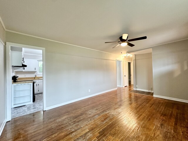 empty room featuring ceiling fan, hardwood / wood-style floors, and ornamental molding