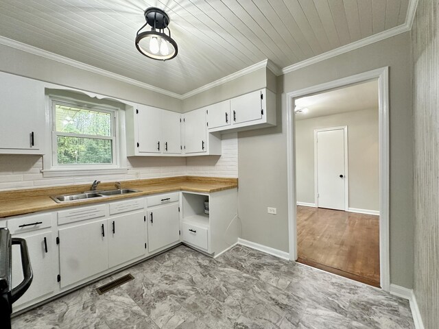 kitchen featuring wooden ceiling, white cabinets, sink, ornamental molding, and tasteful backsplash