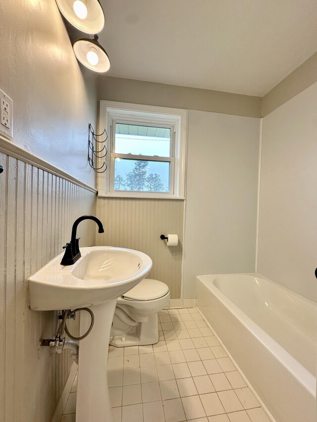 bathroom with tile patterned flooring, toilet, and a bathtub