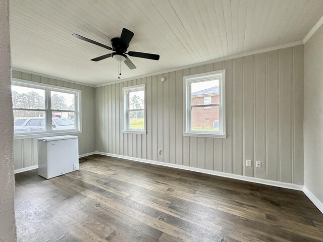 empty room featuring ceiling fan, dark hardwood / wood-style flooring, ornamental molding, and a wealth of natural light