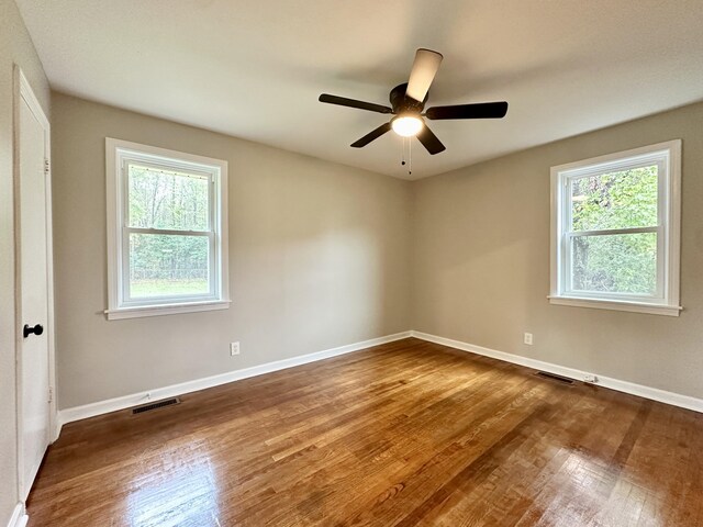 spare room with ceiling fan and dark hardwood / wood-style floors