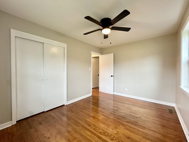 unfurnished bedroom featuring a closet, ceiling fan, and hardwood / wood-style flooring