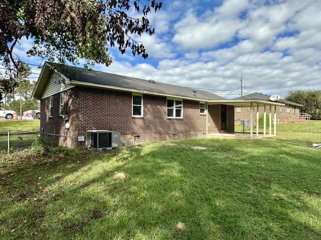 back of house featuring a yard and central AC unit