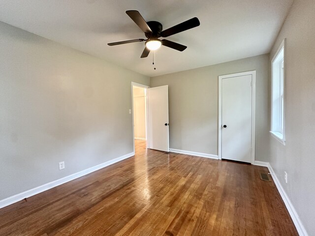 spare room with hardwood / wood-style flooring, ceiling fan, and a healthy amount of sunlight