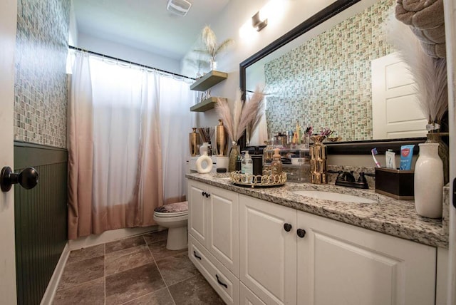 full bathroom with backsplash, toilet, vanity, and shower / tub combo