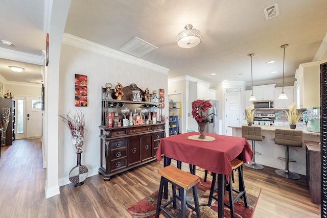 dining area featuring dark hardwood / wood-style flooring and ornamental molding