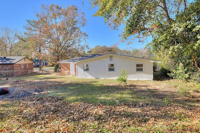 view of home's exterior featuring fence and a lawn