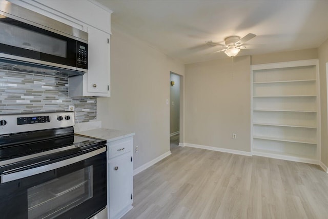 kitchen featuring appliances with stainless steel finishes, light wood-style flooring, white cabinetry, and decorative backsplash