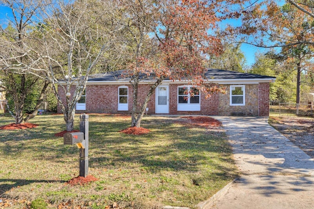 view of front of home with driveway, a front lawn, and brick siding