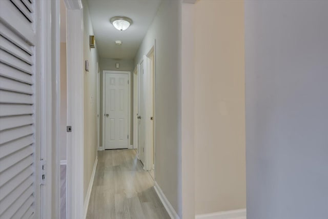 hallway featuring baseboards and light wood-style floors