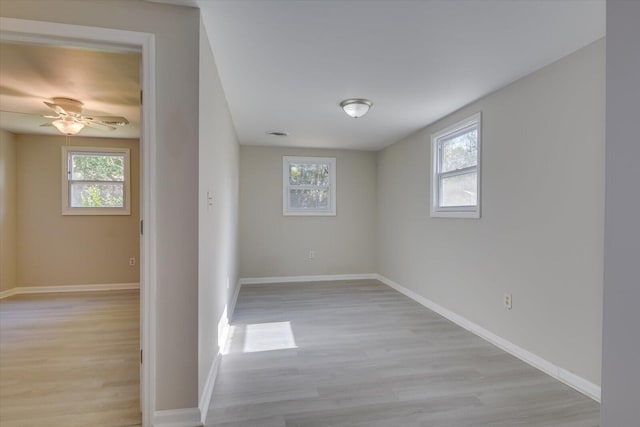 unfurnished room featuring light wood-style floors, baseboards, and a ceiling fan