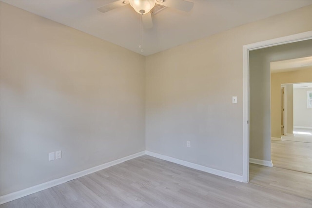 spare room featuring baseboards, ceiling fan, and light wood-style floors