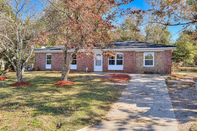 view of front facade with stone siding, brick siding, concrete driveway, and a front yard