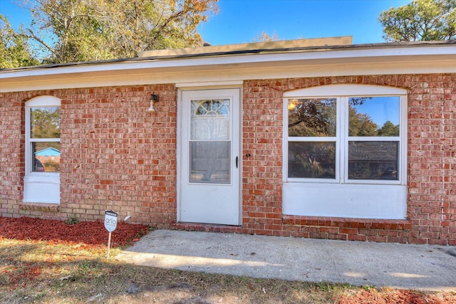 view of exterior entry featuring brick siding