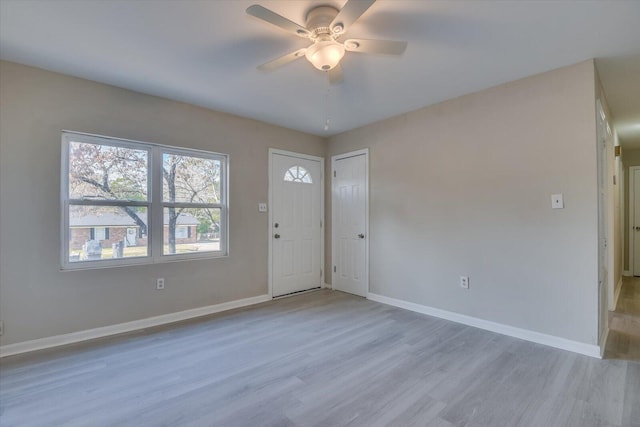 foyer entrance with ceiling fan, wood finished floors, and baseboards