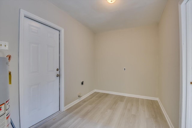 interior space with light wood finished floors, water heater, and baseboards