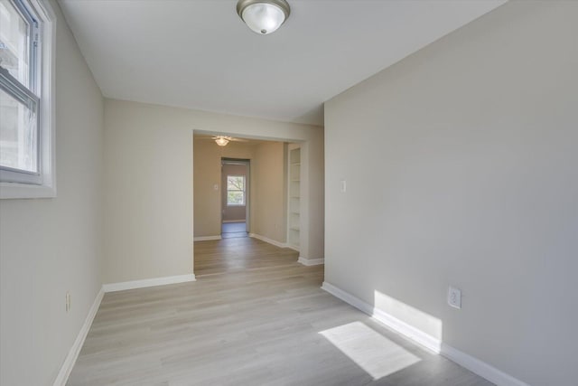 spare room with light wood-style flooring and baseboards