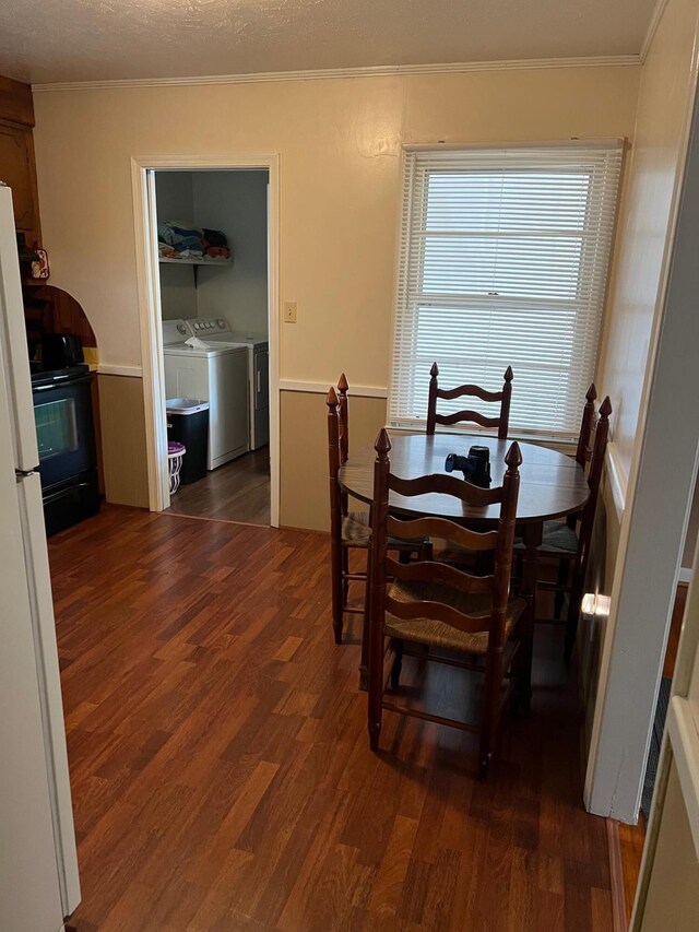 dining area with dark wood-type flooring, washer and dryer, and ornamental molding