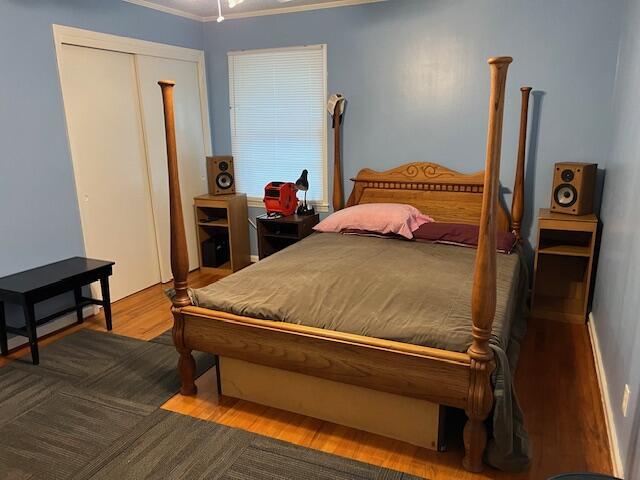 bedroom with light hardwood / wood-style flooring, a closet, and ornamental molding