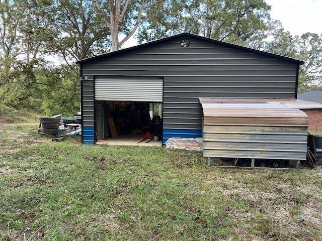 view of side of home featuring an outdoor structure and a lawn