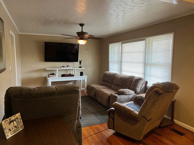 living room with wood-type flooring, a textured ceiling, ceiling fan, and crown molding