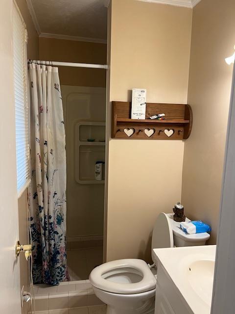 bathroom with curtained shower, tile patterned flooring, crown molding, toilet, and vanity