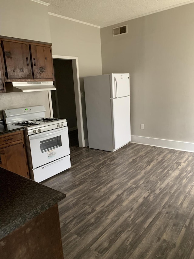 1978 Greene St, Augusta, GA 30904 - kitchen featuring white appliances, a textured ceiling, dark countertops, under cabinet range hood, and visible vents