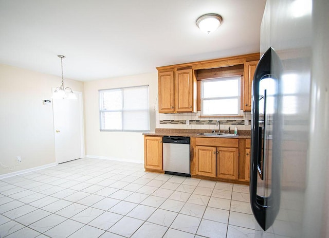 kitchen with dishwasher, sink, backsplash, hanging light fixtures, and black fridge