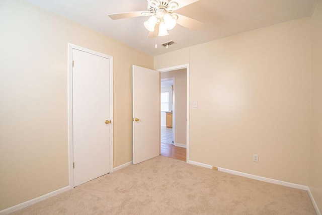 unfurnished bedroom with ceiling fan and light colored carpet