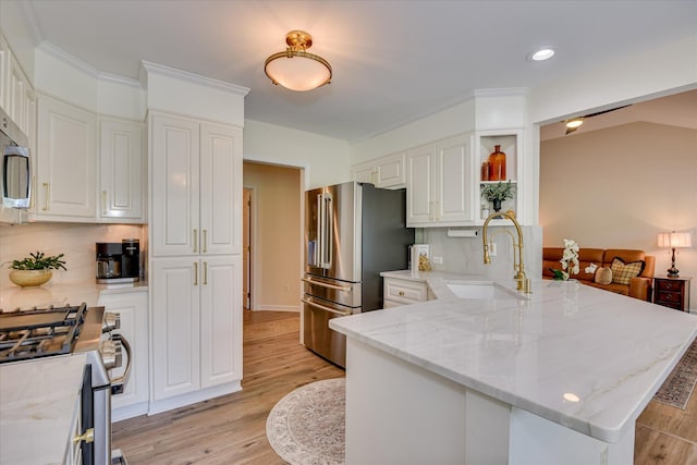 267 Fairway Dr, Mccormick, SC 29835 - kitchen with a sink, appliances with stainless steel finishes, a peninsula, white cabinetry, and light stone countertops