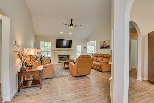 267 Fairway Dr, Mccormick, SC 29835 - living room featuring ceiling fan, a tile fireplace, light wood-style floors, arched walkways, and high vaulted ceiling