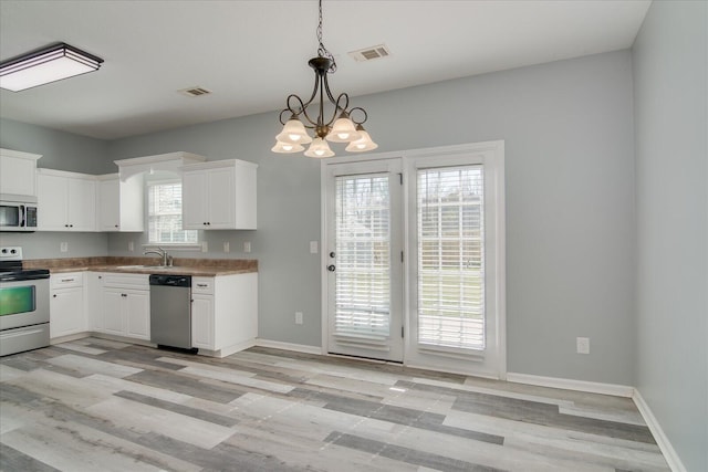 4909 Ashbrooke Way, Grovetown, GA 30813 - kitchen with stainless steel appliances, white cabinets, light wood-style floors, and pendant lighting