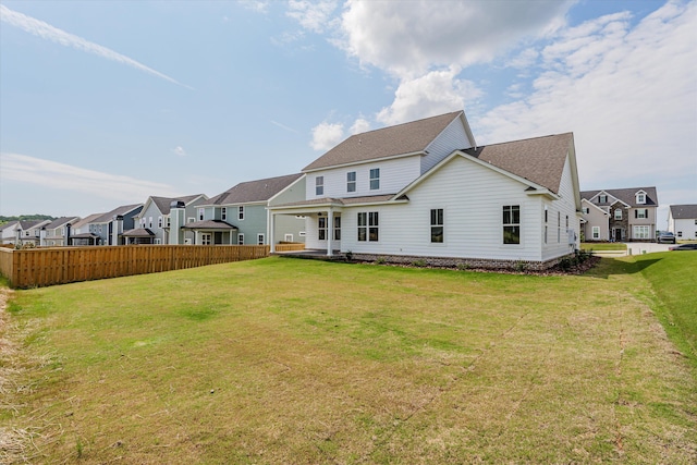 rear view of property featuring a lawn
