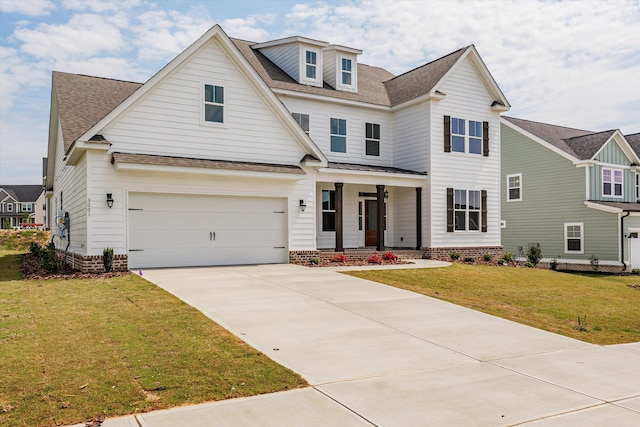view of front of home featuring covered porch, a front yard, and a garage