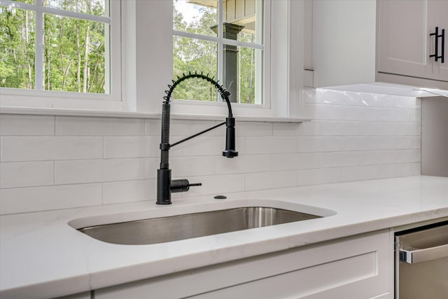 109 Dogwood Trl, Hephzibah, GA 30815 - kitchen view of a sink, tasteful backsplash, dishwasher, white cabinets, and light stone countertops