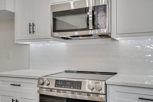 109 Dogwood Trl, Hephzibah, GA 30815 - kitchen with stainless steel appliances, backsplash, white cabinets, and light stone countertops