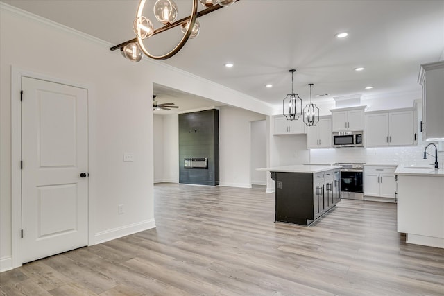 109 Dogwood Trl, Hephzibah, GA 30815 - kitchen featuring stainless steel appliances, a chandelier, ornamental molding, light countertops, and a kitchen island