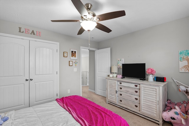 bedroom with a closet, a ceiling fan, and light colored carpet