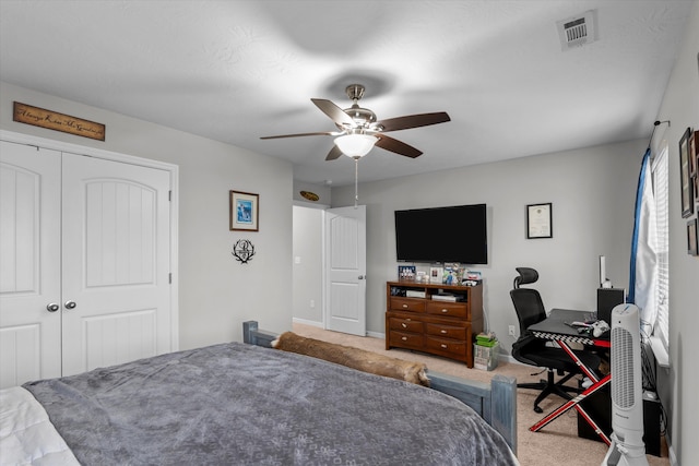 carpeted bedroom featuring a ceiling fan, baseboards, visible vents, and a closet