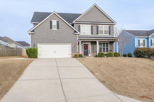 view of front of property with concrete driveway, an attached garage, fence, and a front yard