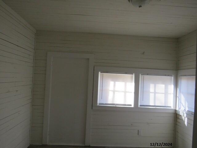 spare room featuring wooden walls