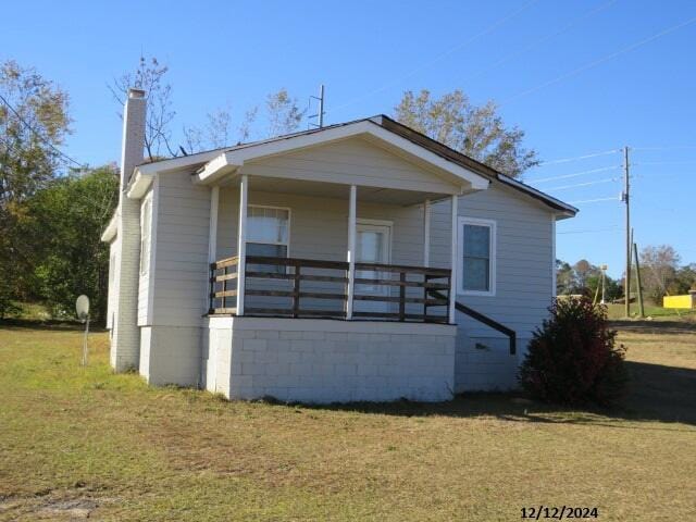 bungalow-style home featuring a porch and a front yard