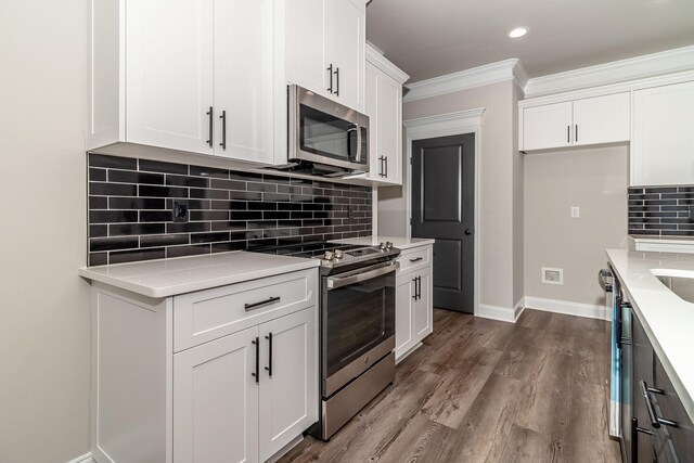 2421 Laurens St, Grovetown, GA 30813 - kitchen with appliances with stainless steel finishes, light countertops, white cabinetry, crown molding, and decorative backsplash