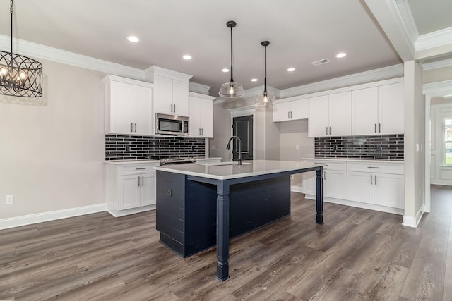 2421 Laurens St, Grovetown, GA 30813 - kitchen with stainless steel microwave, crown molding, a sink, baseboards, and decorative backsplash